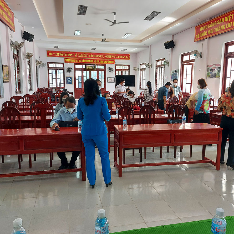A lady adessing a room of people sat around 